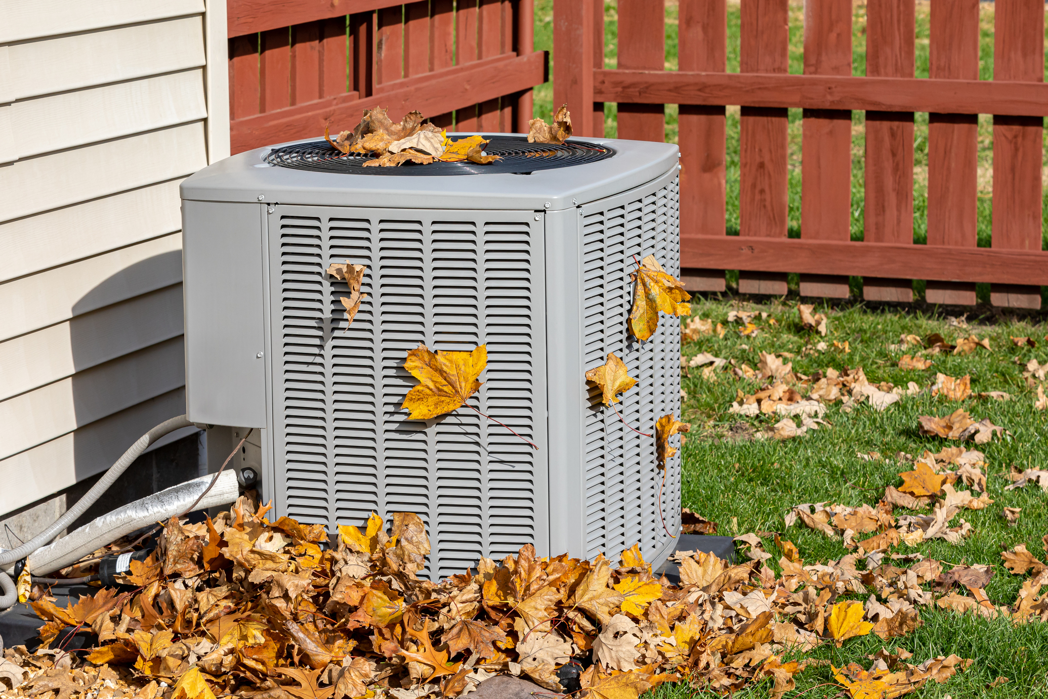 HVAC system cluttered with leaves at a home in cincinnati, OH, needing a tune-up. 